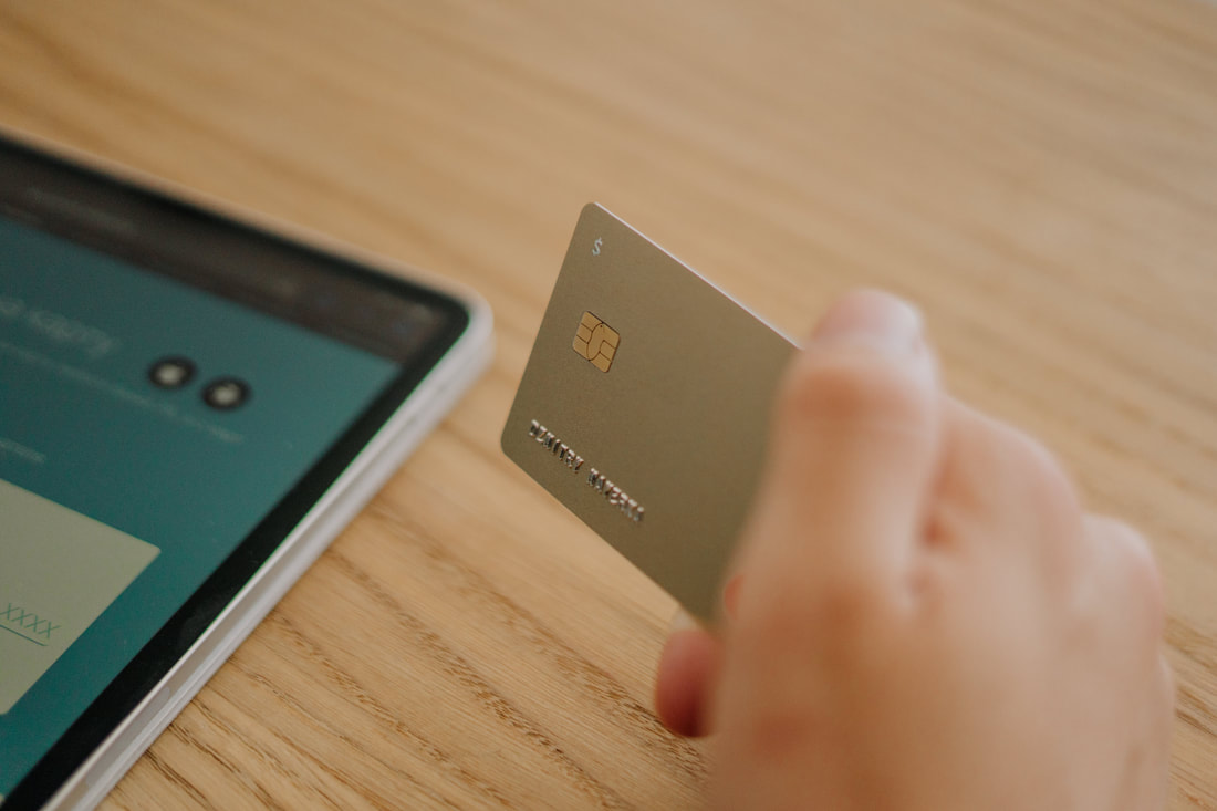 Picture of tablet and hand holding credit card